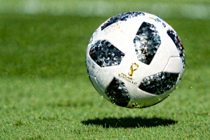 世界杯官方用球特写，悬浮在绿色草皮上方